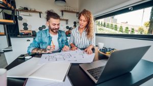 Middle Tennessee homeowner couple reviewing a kitchen remodel proposal and budget worksheet with their designer at a showroom table.