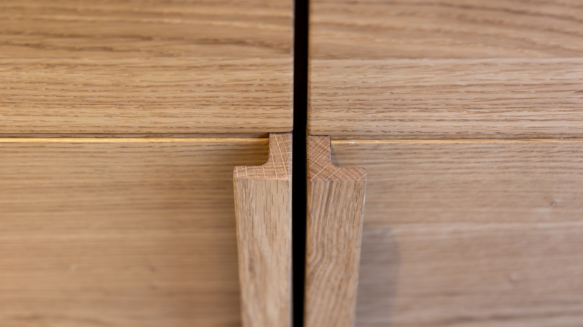 New shaker cabinet door held against an existing kitchen cabinet run to compare finish